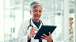 Doctor, woman and typing with tablet in hospital for treatment research, telehealth or online medical advice. Medicine, flare or mature person with digital app for healthcare report or shift schedule