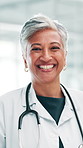 Face, woman and mature doctor laugh in hospital for healthcare, wellness and medicine. Portrait, happy and confident medical professional, cardiologist and expert physician with pride in clinic