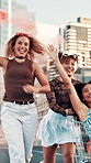 Girl, friends and flare with shopping cart in city with laughing, playful and trendy fashion in street. Gen z people, women and happy with trolley, game and smoke for color with streetwear in town