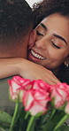 Couple, hug and flowers with love for valentines day, smile and surprise bouquet for relationship, anniversary or date. Man, woman and embrace in home with roses for marriage, celebration or present