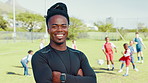 Happy man, soccer coach or face with confidence on grass field for sports training, match or game. Portrait, male person or football trainer with children, smile or arms crossed for physical activity
