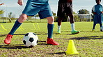 Soccer, players and dribble with ball on grass field for sport practice, training or fitness on pitch. Children, legs and running with football, obstacles or cones for skill, technique or control