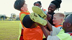 Soccer field, excited and coach with children for celebration, motivation or support for sports game. Outdoor, trainer and kids with carrying player for achievement, football goal or confidence boost