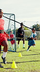 Coach, soccer players and children on field, training and challenge with support, healthy and wellness. Learning, outdoor and sports with kids, practice and workout with football, energy or fitness