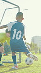 Kick, kids or boy football player with goal for winning at game or match in youth tournament. Sports, celebrate or back of soccer athlete shooting ball in net at target practice on field at stadium