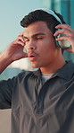 Runner, fitness and man with headphones in city for music, streaming podcast or motivation for sprint. Running, cardio and athlete outdoor with sound for workout, start jog and training to exercise