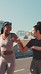 City, women and fist bump for fitness, wellness challenge and training for marathon on bridge. Outdoor, friends and running with endurance for exercise, cardio and morning jog on road with workout