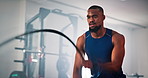 Black man, fitness or gym with battle rope for workout, muscle gain or endurance training. Active, male person or arm exercise with wave or equipment for cardio or physical activity at health club