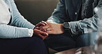 Empathy, couple and holding hands with comfort on sofa for compassion, grief and support. Closeup, people and console in lounge with sympathy, connection and kindness with healing, loss and trauma