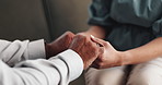 Therapist, holding hands and senior patient for counselling, comfort and support with grief at clinic. People, psychology and consultation for mental health, anxiety and kindness with care on sofa