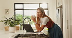 Morning, woman and happy with laptop in kitchen for reading online news, job admin and remote work. Freelancer, person and tech in home for startup proposal, networking and small business research