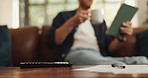 Man, hands or coffee with tablet on sofa for morning beverage, drink or online application at home. Male person, mug and technology with documents or caffeine for start or job research at house
