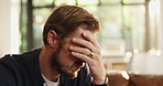 Frustrated man, headache and home with stress on sofa for financial crisis, debt or bankruptcy. Male person, bad news or mistake with migraine or concern for tax inflation or migration at house
