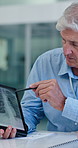 Mature doctor, man and tablet with x ray for cardiology with review, meeting or planning at clinic. Medical director, touchscreen and app with scan for heart, discussion or health service at hospital