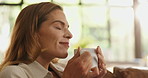 Happy, coffee and woman on sofa in home for calm, relaxing and peaceful morning on weekend. Smile, chilling and female person with cup of warm beverage, tea or latte in living room at apartment.