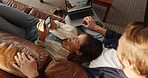 Above, laptop and couple on sofa, cellphone and online reading with website info. Home, subscription or man with woman, computer and smartphone with social media, chatting and weekend break in lounge