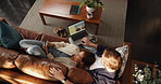 Couple, laptop and sofa with search for holiday location, discount and booking with screen in home. Woman, man and above with computer, smartphone and app for vacation planning in lounge at apartment