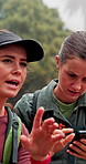 Women, friends and hiking with phone, search and digital map for location, thinking and confused in woods. People, smartphone and mobile app for direction, path or trail with trekking in Argentina