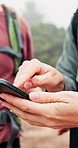 People, hands and hiking with phone for navigation, path finding or system app in outdoor forest. Closeup, hikers or friends with mobile smartphone for map location, destination or tracking route