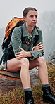 Backpacking, nature and woman with cold for hiking on adventure, vacation or exploring in winter. Weather, relax and female person on tree branch for break of trekking outdoor in forest on holiday.
