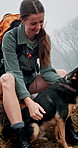 Hiker, dog and woman with smile, environment and countryside with journey, winter and care. Person, outdoor and hike in forest, fog and pet owner with vacation, weekend break and bonding together