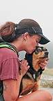 Woman, hiking and dog in nature with hug, kiss and outdoor on trail with stroke, love and bonding. Girl, pet animal and embrace with care, adventure and trekking with break, rest and path in England