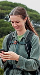 Happy woman, hiker and typing with phone for navigation, destination or sightseeing in nature. Female person, user or smile on mobile smartphone for hiking app, route or trekking software in forest