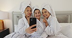 Friends, spa and girls with selfie in hotel room for pamper date memory, social media or bonding. Blow kiss, people and photography on bed for luxury self care, profile picture update and hospitality