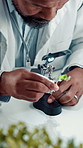 Scientist, black man and plant with magnifying glass in laboratory for botany, medical research and breakthrough. Chemist, biotechnology and examine sample for pharmaceutical or sustainable ecology