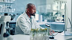 Lab, typing and man with computer, medical research or cure for plant diseases, studying and online. Thinking, biologist and mature person with tech for breakthrough, planning and sustainability