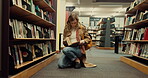 Student, girl and reading a book in library for exam preparation, information search or knowledge. College, gen z person and backpack on floor for course resources, thesis citation and essay material