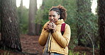 Girl, hiking and smell coffee in woods with backpack, thinking or sightseeing on break in summer. African woman, smile and reflection with warm drink, aroma and trekking in forest on path in Kenya