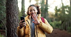 Woman, hiking and phone with video call in forest with wave, smile or contact on break in summer. African person, smartphone and happy with hello, talking and social network in woods on path in Kenya