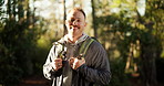 Face, hiking and man with smile, outdoor and nature with fitness, countryside and environment. Portrait, happy person and hiker in woods, hobby and exercise with break, journey or holiday with health