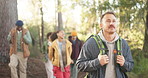 Hiking, man and friends with walking in forest for travel adventure, sightseeing and explore nature. Backpacker, group and backpack in woods with holiday journey, fresh air and hobby with wellness