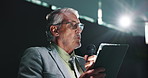 Presentation, microphone and businessman with tablet on a stage for financial summit with investment. Digital technology, meeting and mature male finance secretary with speech for economy development