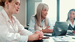 Financial manager, talking or business people in meeting for charts paperwork, funding or sales feedback. Team, women and analyst with mature mentor for finance review and online report on laptop
