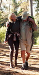 Senior couple, hiking and help for injury, ankle sprain and happy with care, love and adventure in woods. People, support and balance with walk, fatigue and guide for trekking in retirement in Spain