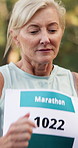 Marathon, woman and running competition in forest for fitness challenge, sports event or workout. Runner, mature person and exercise in nature for cardio performance, ednurance training and momentum