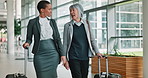 Business women, talking and luggage at airport with smile, discussion and mentor on corporate trip. People, advice and employee in conversation on travel, baggage or team in lobby for boarding flight
