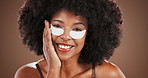 Beauty, face and woman with eye patches in studio for dark circles, hyaluronic acid and hydration. Skincare, african person and happy with cosmetic product for puffiness reduction on brown background