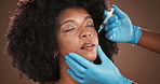 Beauty, lip filler and needle with black woman in studio for antiaging treatment or plastic surgery. Face, hands of surgeon and syringe with person in clinic for cosmetic procedure or injection