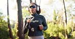 Woman, running and fitness with headphones in forest for spring jog, workout or outdoor exercise. Active, female person or runner with sunglasses for health, cardio or wellness in woods or nature