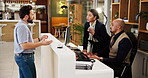 Unhappy, man and complaining to manager, hotel and disappointed with customer service and reception. Motel, receptionist and checking for reservation on computer, discussion or talking to upset guest