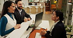 Hotel, people and talking to receptionist, reservation and customer service for colleagues and chat. Arrival, guest and discussion with concierge for check in, man and woman on business trip in motel