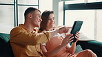 Couple, laughing or pointing to tablet on sofa for online shopping, app choice or purchase decision. Relax, people and bonding together with digital tech in home for web browsing or streaming service