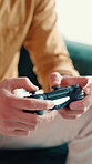 Hands, controller and man gaming in home for entertainment on weekend with console in living room. Online subscription, esports and male person on sofa for playing video game with tech in apartment.