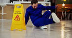 Janitor, accident and man slipping in office with workplace safety, ignore warning sign and risk. Danger, hazard and cleaner fall on wet floor for workers compensation, negligence and legal claim