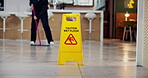 Janitor, person and office with wet floor sign, hygiene service and caution for disinfection. Attention, safety and warning for risk, cleaning and employee with tile polishing and maintenance worker