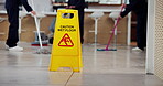 Janitor, teamwork and office with wet floor sign, hygiene service and caution for disinfection. Attention, safety and warning for risk, cleaning and people with tile polishing and maintenance worker